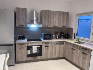 a kitchen with wooden cabinets and a stove top oven at bookandstay24 Die-burg 4 Zimmerwohnung mit Küche und Balkon bei Darmstadt, Frankfurt, RheinMain Gebiet in Dieburg