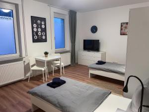 a bedroom with a bed and a table and a tv at bookandstay24 Die-burg 4 Zimmerwohnung mit Küche und Balkon bei Darmstadt, Frankfurt, RheinMain Gebiet in Dieburg