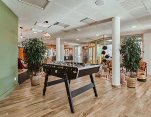 a ping pong table in a room with potted plants at Kabane Montpellier in Lattes