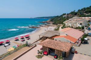 eine Luftaufnahme eines Strandes mit Sonnenschirmen in der Unterkunft Hôtel et Résidence Ta Kladia - Omigna in Cargèse + 104 Fotos