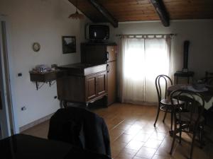 a living room with a kitchen and a table and a window at Agriturismo Il Casotto in Maida