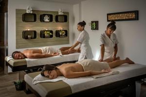 a couple of people laying on beds in a room at Grand Hotel Resort&SPA Ma&Ma - Adults Only in La Maddalena