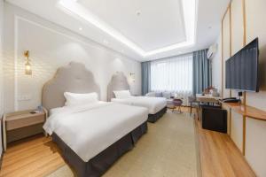a hotel room with two beds and a flat screen tv at Return to Emei Hotel in Baoguosi