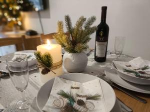 a table with a candle and plates and a bottle of wine at Apartman Ema in Donovaly