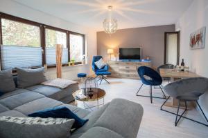 ein Wohnzimmer mit einem Sofa, Stühlen und einem TV in der Unterkunft Bismarckstraße 27 in Bad Sachsa
