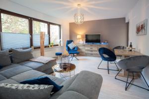 ein Wohnzimmer mit Sofa, Sesseln und Fernseher in der Unterkunft Bismarckstraße 27 in Bad Sachsa