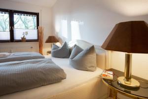 ein Schlafzimmer mit einem Bett mit Kissen und einer Lampe in der Unterkunft Bismarckstraße 27 in Bad Sachsa