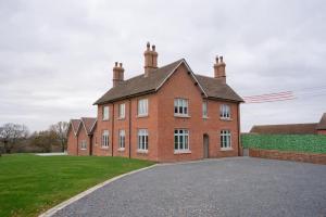 a large red brick building with a driveway at Grange House - Sleeps 24 in Alvechurch