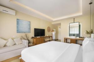 a living room with a white bed and a couch at Return to Emei Hotel in Baoguosi