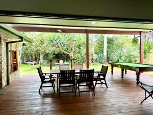 a patio with a table and ping pong tables and chairs at Pandanus Paradise. Newly renovated 4 bedroom home in Cabarita Beach