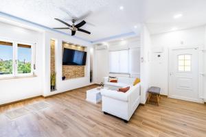a living room with a white couch and a ceiling fan at Holiday house Nada with the pool in Fažana