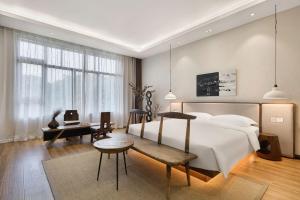 a bedroom with a bed and a table and a desk at Return to Emei Hotel in Baoguosi