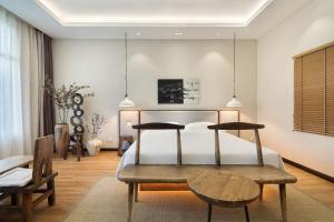 a bedroom with a bed and a table in it at Return to Emei Hotel in Baoguosi