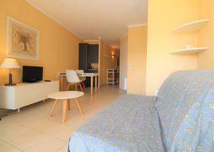 a bedroom with a bed and a living room at GASDON - Golfe de St-Tropez - Gassin - Studio cabine dans résidence avec piscine bord de mer in Gassin