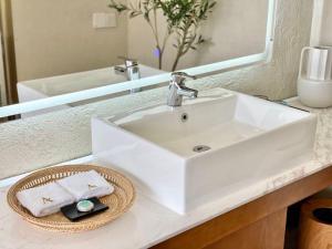 a white sink in a bathroom with a mirror at Return to Emei Hotel in Baoguosi