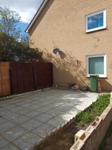 a patio in front of a house with a fence at Comfortable holiday home in Basildon Essex in Laindon