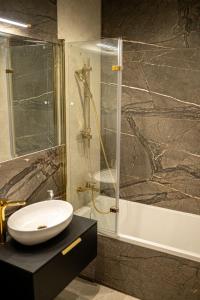 a bathroom with a sink and a shower at Apartament ELEGANCE in Zamość +11 photos