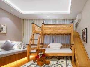 a teddy bear sitting on the floor in a bedroom at Return to Emei Hotel in Baoguosi