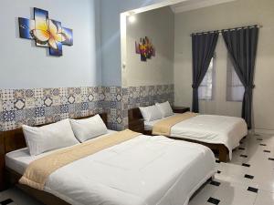 una camera da letto con due letti e uno specchio di ADA Homestay a Borobudur