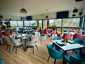 a restaurant with tables and chairs and windows at Eco Camp Lake Mladost in Veles