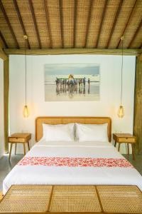 a bedroom with a bed and a painting on the wall at Poolside Room with Lounge in Kaba-Kaba in Tabanan