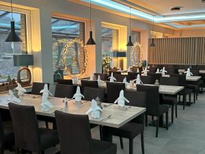 ein Esszimmer mit Tischen, Stühlen und Lampen in der Unterkunft Hotel Paulushof in Rurberg