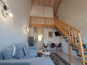 een woonkamer met een blauwe bank en een trap bij Loft Matina in Nafplio