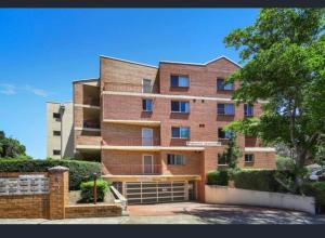 a large brick building with a gate in front of it at Sai House in Blacktown