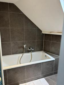 a bath tub with a faucet in a bathroom at gezellige woning met tuin centrum Leuven in Leuven +9 photos