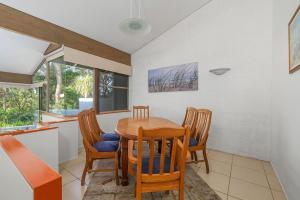 eine Küche und ein Esszimmer mit einem Holztisch und Stühlen in der Unterkunft Hyams Beach Haven, Hyams Beach in Hyams Beach + 16 Fotos