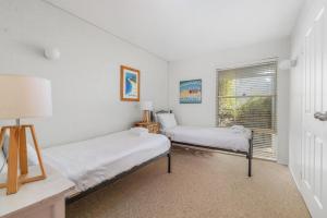 zwei Betten in einem Zimmer mit Fenster in der Unterkunft Hyams Beach Haven, Hyams Beach in Hyams Beach
