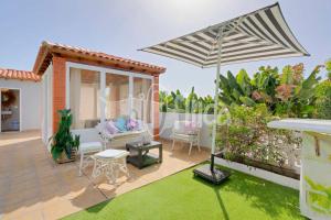 a patio with an umbrella and a garden at Villa Bio Finca With Pool in Playa Paraiso