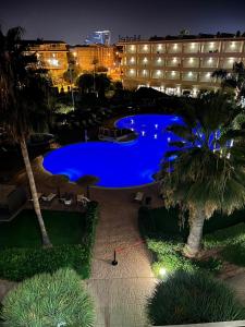 a large blue swimming pool in front of a hotel at AGH Canet in Canet de Berenguer