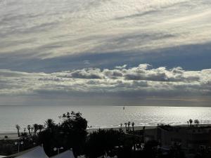 a beach with a cloudy sky and the ocean at AGH Canet in Canet de Berenguer