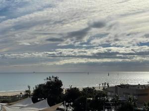 a view of the beach and the ocean on a cloudy day at AGH Canet in Canet de Berenguer