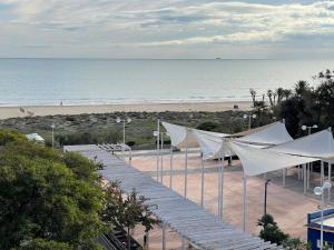 a view of a beach with white tents and the ocean at AGH Canet in Canet de Berenguer
