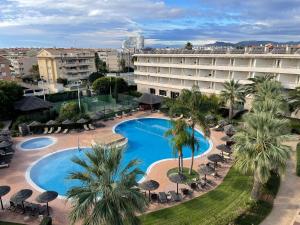an overhead view of a hotel with a pool and palm trees at AGH Canet in Canet de Berenguer