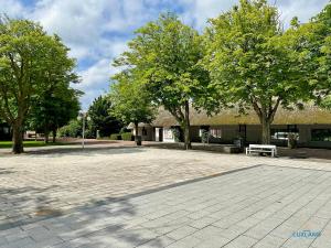 a park with a bench in front of a building at Haus Elbe Döse Wohnung 2 in Cuxhaven +12 photos
