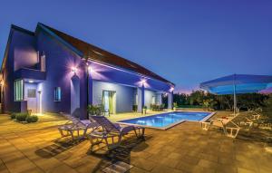 a villa with a swimming pool with chairs and a house at 6 Bedroom Amazing Home In Bilice in Bilice