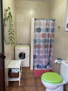 a bathroom with a toilet and a washing machine at Casa Adelfa in Algodonales