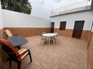 a patio with a table and chairs and a building at Casa Adelfa in Algodonales