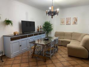 a living room with a couch and a table with a tv at Casa Adelfa in Algodonales