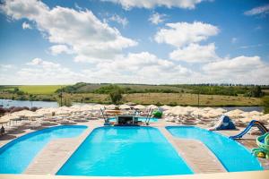 a pool at a resort with chairs and a body of water at Парк Готель Скіфія in Zakharovka