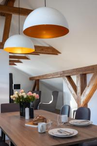 a dining room table with two lights and flowers at Lieblingsquartier komplett in Sankt Andreasberg