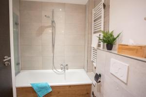 een badkamer met douche en ligbad bij Chalet Bergzeit 7 in Braunlage