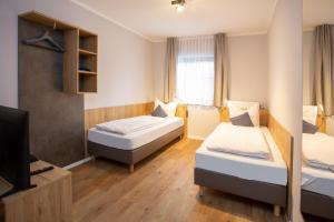 een kleine kamer met 2 bedden en een televisie bij Chalet Bergzeit 7 in Braunlage