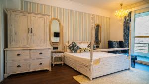 a bedroom with a bed and a dresser and a mirror at Aloha on the Ganges Ganga View with Infinity Pool 2BHK 203 by Almost Heaven in Rishīkesh