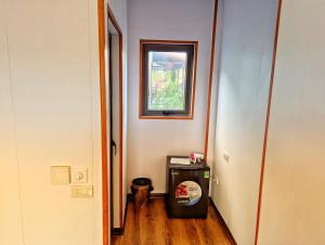 a hallway with a window and a small refrigerator at Ninh Binh Greenland Homestay in Ninh Binh