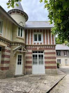 a large brick house with two white doors at The Coach House in Saint-Côme-de-Fresné