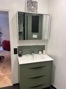 a bathroom with a sink and a mirror at The Coach House in Saint-Côme-de-Fresné